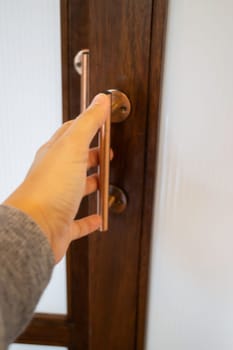 Hand on metal door holder, stock photo