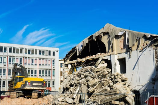 Construction site digger yellow demolishing house for a reconstruction
