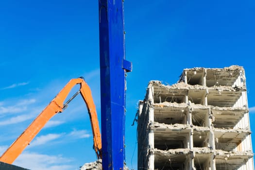 Construction site digger yellow demolishing house for a reconstruction