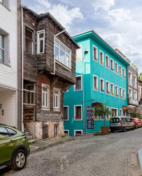 Istanbul, Turkey - August 30, 2022: Cobblestone alley, with beautiful old wooden and colorful traditional houses, painted in pistage, near Sultanahmet square, Fatih district, in a summer day