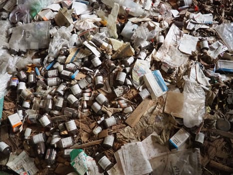 Sremska Mitrovica, Serbia. 07 February 2021, Room with trash in an abandoned house. Packages, paper, plastic items, medicines, bottles, packages, syringes on a wooden floor