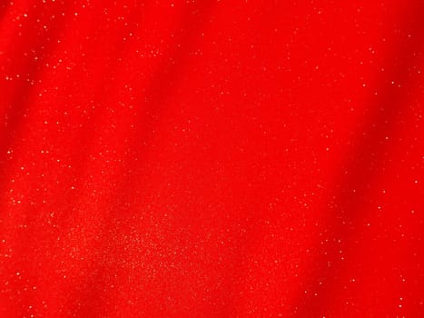 Red background, arched scarlet. Nice holiday color. Background with shimmer, gradient, white dots. Photograph of sparkling colored paper