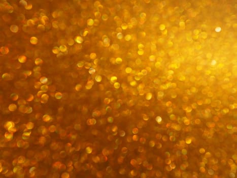 Bokeh light of gold glitters. Golden glitter texture background. Sparkling glitter wrapping paper with sequins and sparkles. Festive golden bokeh and glitter. Beautiful background
