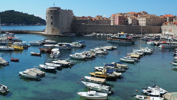 Dubrovnik, Croatia, 08.14. 2022 City port summer tourist attraction. Tourists walk, get into boats and ships and go on boat trips. Adriatic Sea. Travel and recreation. Private boats of local citizens