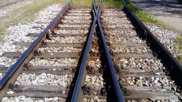 railways. Rails and sleepers on the ground near the station. Long way concept. Interlacing of tracks, railway arrows. Change of direction. Metal heavy rails.