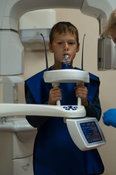 Jaw computed tomography, check up teeth in dental clinic. Little boy on x-ray diagnostics. Circular snapshot of jaw on modern medical equipment. CT scanning, stomatology and radiology.