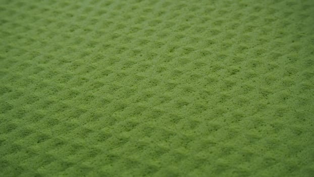 Sponge fibers sponge texture pattern surface close-up green yellow background.