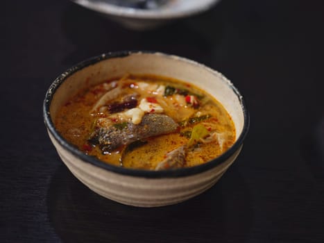 Traditional Thai soup Tom Yum with fish , coconut milk and chili pepper and rice bowl.