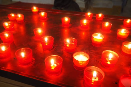 Memorial Day with candle. Commemorative candles are lit. Candle flames burn in the cemetery. Burning candles in the catholic church in Dubrovnik Croatia. Lots of candles. The flame sways in the draft