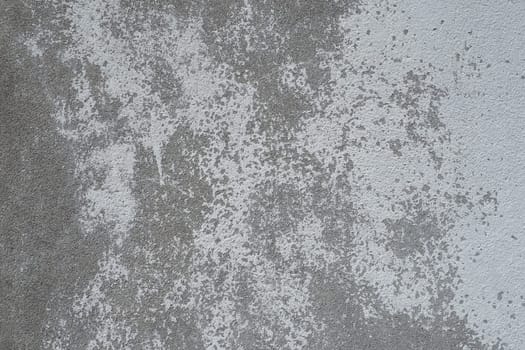 Plastered wall texture. Whitewash surface. Abstract background. Retro wall built structure texture. Cracks and bumps on the concrete wall. Uneven coloring with water-based paint. Old tattered plaster.