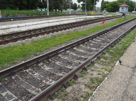 Usman, Lipetsk region, Russia August 7, 2021. Railway crossing. Rails, sleepers, traffic control point. The cars are waiting for the the movement. Traffic light red. Railway equipment and signs.