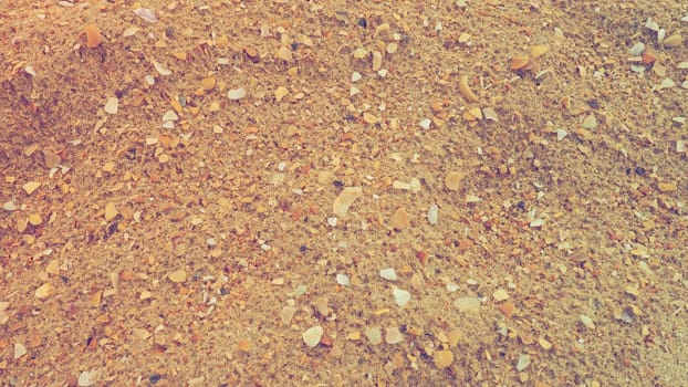 Sand with seashells background. Wet coarse quartz sand. Broken seashells. Beach after heavy rain. Silica. Crushed quartz sand, natural brown material after a storm. Dents from drops in the sand. Anapa