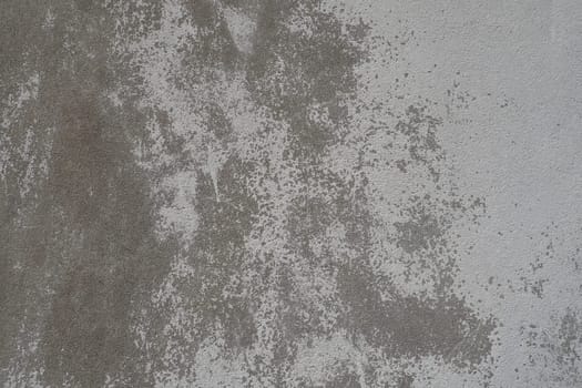 Plastered wall texture. Whitewash surface. Abstract background. Retro wall built structure texture. Cracks and bumps on the concrete wall. Uneven coloring with water-based paint. Old tattered plaster.
