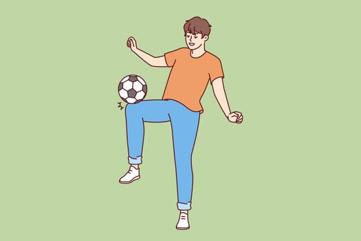 Happy man kicking soccer ball wanting to become famous major league player and compete in international sports competitions. Young promising soccer player training alone with smile doing tricks