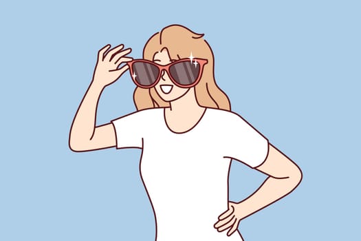 Happy woman with giant sunglasses on face smiles and looks around looking for acquaintances. Positive girl in casual t-shirt of department sunglasses for going to beach or walking in summer park