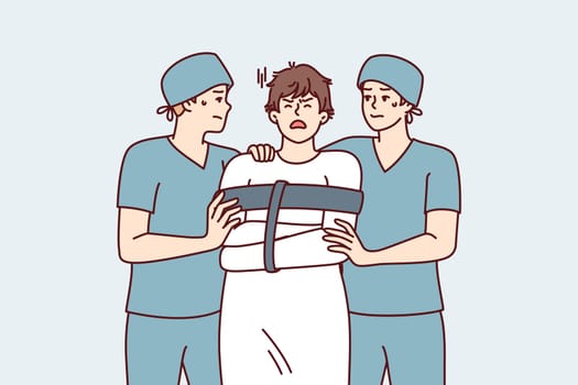 Two orderlies lead crazy man in straitjacket suffering from mental problems or schizophrenic illness. Crazy guy admitted to psychiatric hospital for treatment after seasonal exacerbation