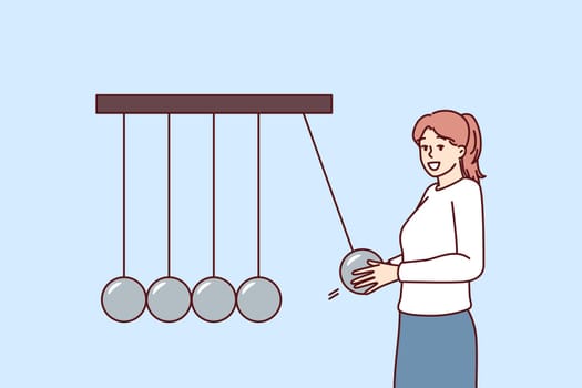 Positive business woman near Newton giant cradle symbolizing business management and employee motivation. Girl manager of corporation smiling working in personnel control department