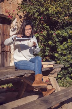 woman puts down the reading books and pours a cup of tea from the thermos, in the open air