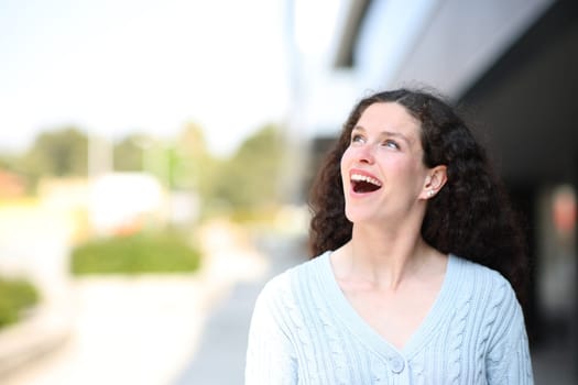 Front view of an amazed woman in the street looking at side