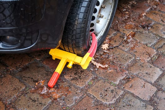 A car is prevented from moving forward by a parking claw, tire claw, immobilizer.