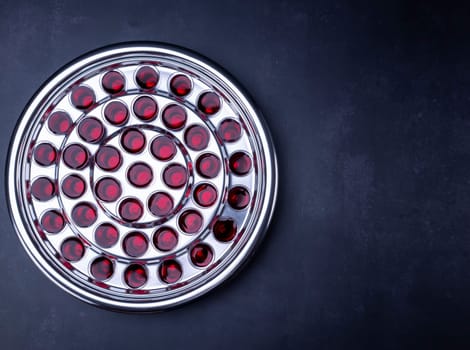 Communion glass cups on tray filled with wine the symbol of Jesus Christ blood on black background. Easter Passover and Lord Supper concept.