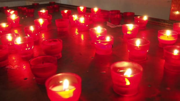 Memorial Day with candle. Commemorative candles are lit. Candle flames burn in the cemetery. Burning candles in the catholic church in Dubrovnik Croatia. Lots of candles. The flame sways in the draft