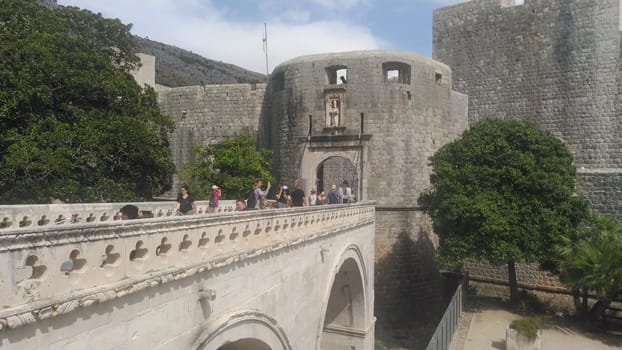 Pile Gate Dubrovnik Croatia August 14 2022 People men and women walk along the stone bridge to the gate of the Old City. Crowd of tourists. Busy entrance. The main entrance to Old Town, busy Pile Gate
