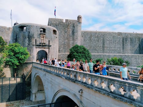 Pile Gate Dubrovnik Croatia August 14 2022 People men and women walk along the stone bridge to the gate of the Old City. Crowd of tourists. Busy entrance. The main entrance to Old Town, busy Pile Gate
