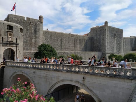 Pile Gate Dubrovnik Croatia August 14 2022 People men and women walk along the stone bridge to the gate of the Old City. Crowd of tourists. Busy entrance. The main entrance to Old Town, busy Pile Gate