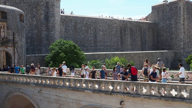 Pile Gate Dubrovnik Croatia August 14 2022 People men and women walk along the stone bridge to the gate of the Old City. Crowd of tourists. Busy entrance. The main entrance to Old Town, busy Pile Gate