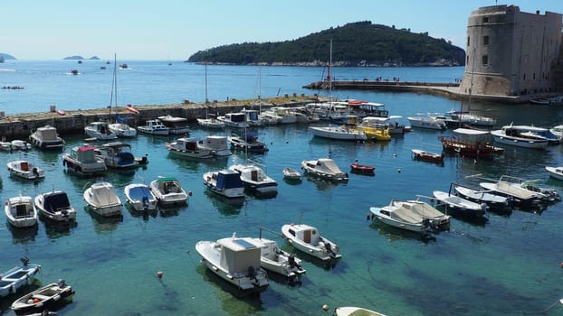 Dubrovnik, Croatia, 08.14. 2022 City port summer tourist attraction. Tourists walk, get into boats and ships and go on boat trips. Adriatic Sea. Travel and recreation. Private boats of local citizens