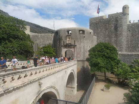 Pile Gate Dubrovnik Croatia August 14 2022 People men and women walk along the stone bridge to the gate of the Old City. Crowd of tourists. Busy entrance. The main entrance to Old Town, busy Pile Gate