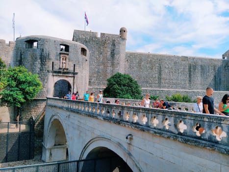 Pile Gate Dubrovnik Croatia August 14 2022 People men and women walk along the stone bridge to the gate of the Old City. Crowd of tourists. Busy entrance. The main entrance to Old Town, busy Pile Gate