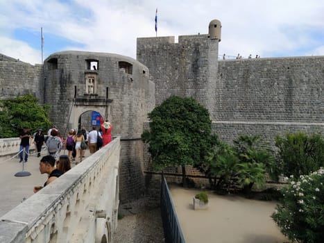 Pile Gate Dubrovnik Croatia August 14 2022 People men and women walk along the stone bridge to the gate of the Old City. Crowd of tourists. Busy entrance. The main entrance to Old Town, busy Pile Gate