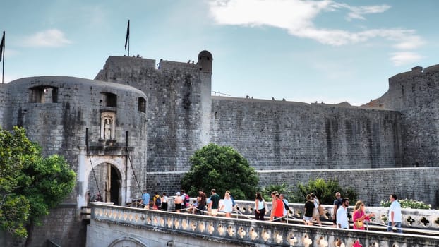 Pile Gate Dubrovnik Croatia August 14 2022 People men and women walk along the stone bridge to the gate of the Old City. Crowd of tourists. Busy entrance. The main entrance to Old Town, busy Pile Gate