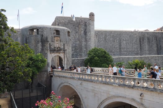 Pile Gate Dubrovnik Croatia August 14 2022 People men and women walk along the stone bridge to the gate of the Old City. Crowd of tourists. Busy entrance. The main entrance to Old Town, busy Pile Gate