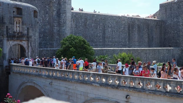 Pile Gate Dubrovnik Croatia August 14 2022 People men and women walk along the stone bridge to the gate of the Old City. Crowd of tourists. Busy entrance. The main entrance to Old Town, busy Pile Gate