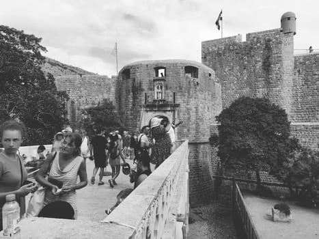 Pile Gate Dubrovnik Croatia August 14 2022 People men and women walk along the stone bridge to the gate of the Old City. Crowd of tourists. Busy entrance. The main entrance to Old Town, busy Pile Gate