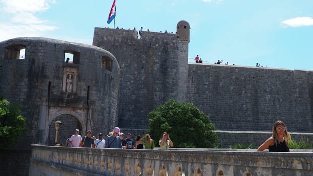 Pile Gate Dubrovnik Croatia August 14 2022 People men and women walk along the stone bridge to the gate of the Old City. Crowd of tourists. Busy entrance. The main entrance to Old Town, busy Pile Gate