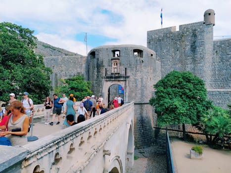 Pile Gate Dubrovnik Croatia August 14 2022 People men and women walk along the stone bridge to the gate of the Old City. Crowd of tourists. Busy entrance. The main entrance to Old Town, busy Pile Gate