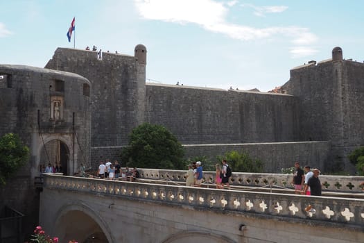 Pile Gate Dubrovnik Croatia August 14 2022 People men and women walk along the stone bridge to the gate of the Old City. Crowd of tourists. Busy entrance. The main entrance to Old Town, busy Pile Gate