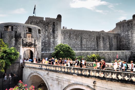 Pile Gate Dubrovnik Croatia August 14 2022 People men and women walk along the stone bridge to the gate of the Old City. Crowd of tourists. Busy entrance. The main entrance to Old Town, busy Pile Gate