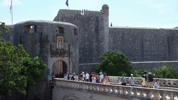 Pile Gate Dubrovnik Croatia August 14 2022 People men and women walk along the stone bridge to the gate of the Old City. Crowd of tourists. Busy entrance. The main entrance to Old Town, busy Pile Gate