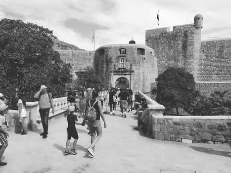Pile Gate Dubrovnik Croatia August 14 2022 People men and women walk along the stone bridge to the gate of the Old City. Crowd of tourists. Busy entrance. The main entrance to Old Town, busy Pile Gate