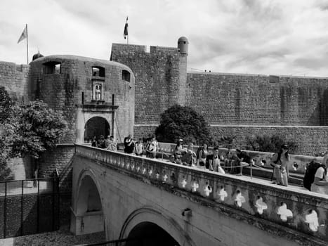 Pile Gate Dubrovnik Croatia August 14 2022 People men and women walk along the stone bridge to the gate of the Old City. Crowd of tourists. Busy entrance. The main entrance to Old Town, busy Pile Gate