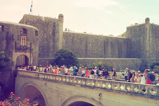Pile Gate Dubrovnik Croatia August 14 2022 People men and women walk along the stone bridge to the gate of the Old City. Crowd of tourists. Busy entrance. The main entrance to Old Town, busy Pile Gate