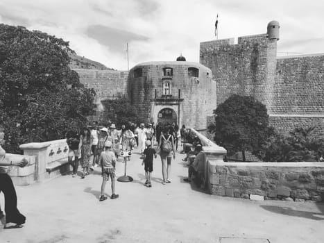 Pile Gate Dubrovnik Croatia August 14 2022 People men and women walk along the stone bridge to the gate of the Old City. Crowd of tourists. Busy entrance. The main entrance to Old Town, busy Pile Gate