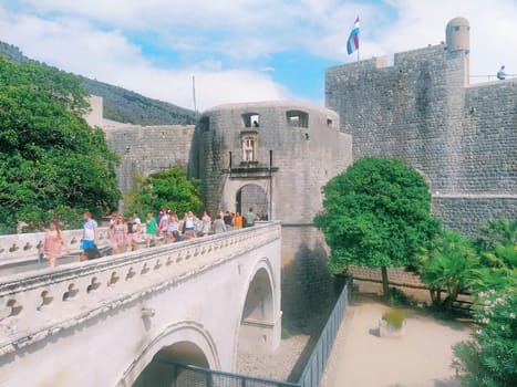 Pile Gate Dubrovnik Croatia August 14 2022 People men and women walk along the stone bridge to the gate of the Old City. Crowd of tourists. Busy entrance. The main entrance to Old Town, busy Pile Gate