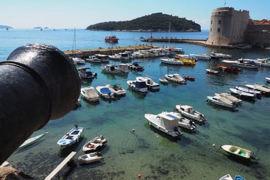 Dubrovnik, Croatia, 08.14. 2022 City port summer tourist attraction. Tourists walk, get into boats and ships and go on boat trips. Adriatic Sea. Travel. Cannon muzzle. Private boats of local citizens
