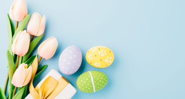 Happy Easter Day Concept. Flat lay of holiday banner background design white easter eggs and beautiful tulip flowers on blue background with empty copy space, celebration greeting card